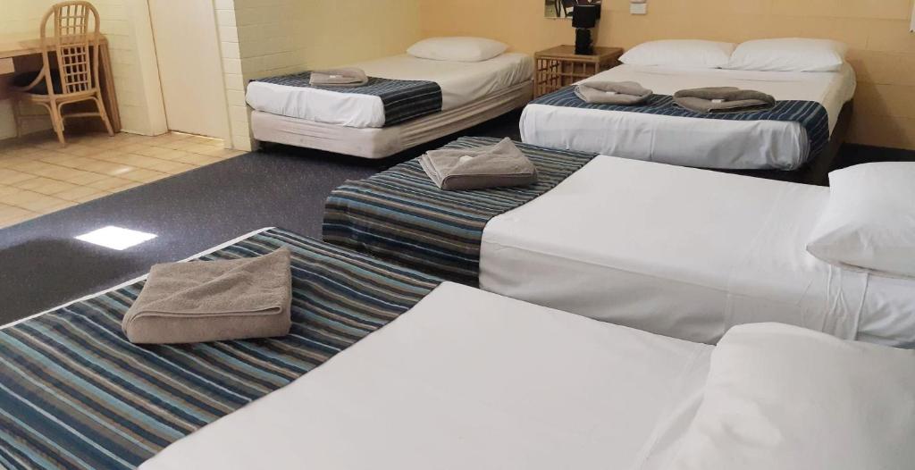 a room with three beds and a room with three at Burdekin Motor Inn in Home Hill