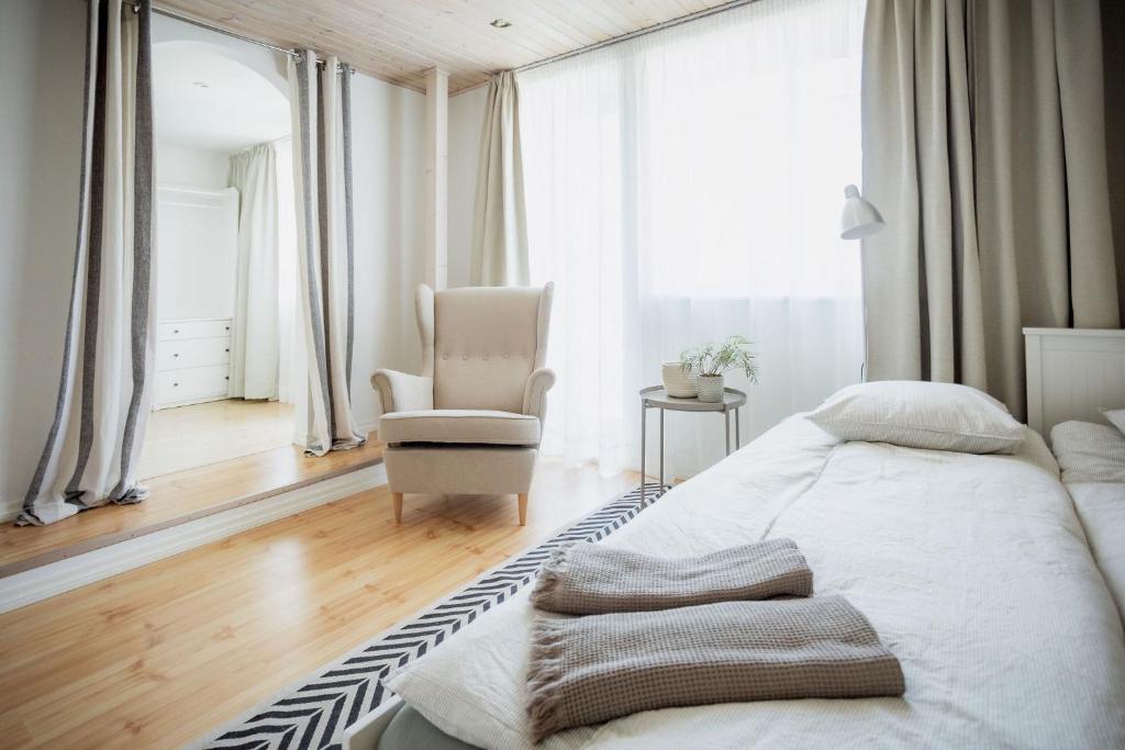 a bedroom with a large bed and a chair at Nautika Central Residence in Kuressaare