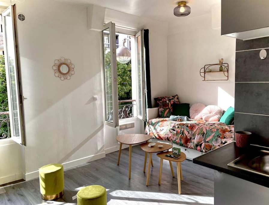 un petit salon avec un canapé et une table dans l'établissement Charming Bright Sunny Studio near Canal St Martin, à Paris