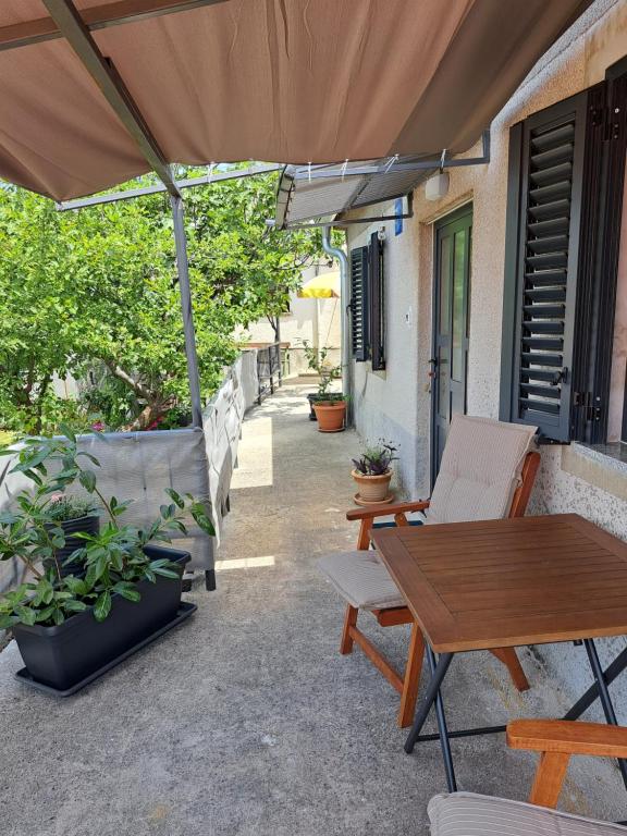 a patio with a table and chairs and an umbrella at Tiny House for 2 Hreljin Crikvenica in Hreljin