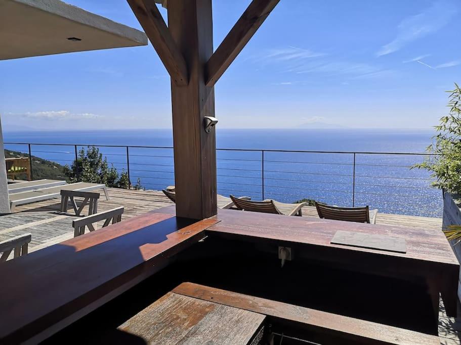a patio with a table and chairs and the ocean at Villa 10 p.Brando 170 m2 vue mer panoramique in Brando