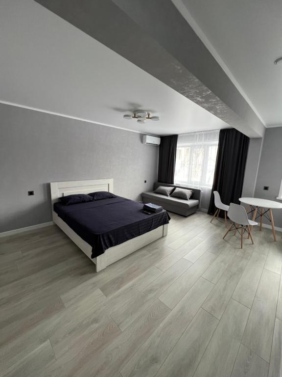 1 dormitorio con cama, sofá y mesa en Однокомнатная квартира, en Baljash