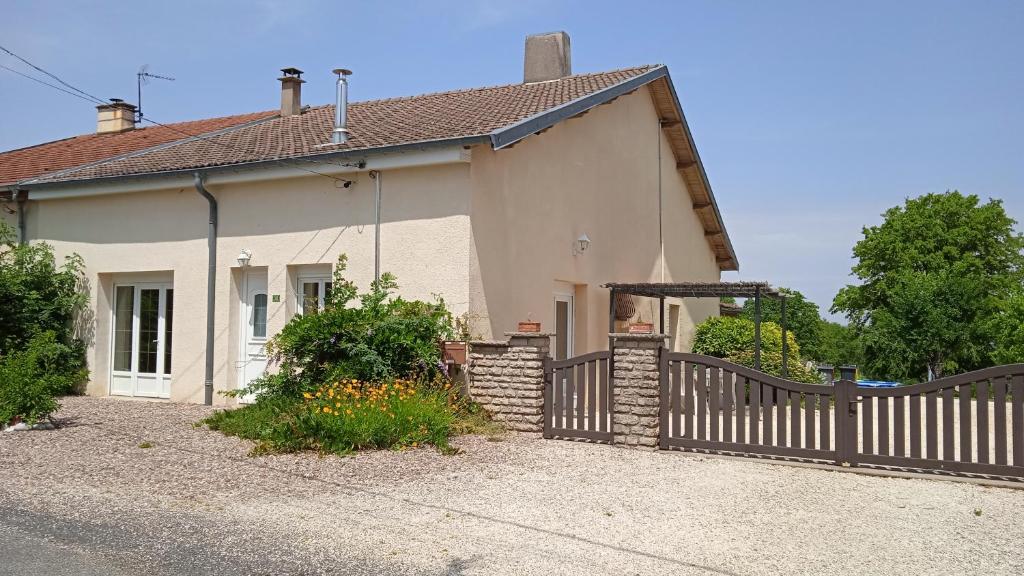 a white house with a wooden fence in front of it at Les Jardins des 3 Provinces- Gîte in Montcharvot