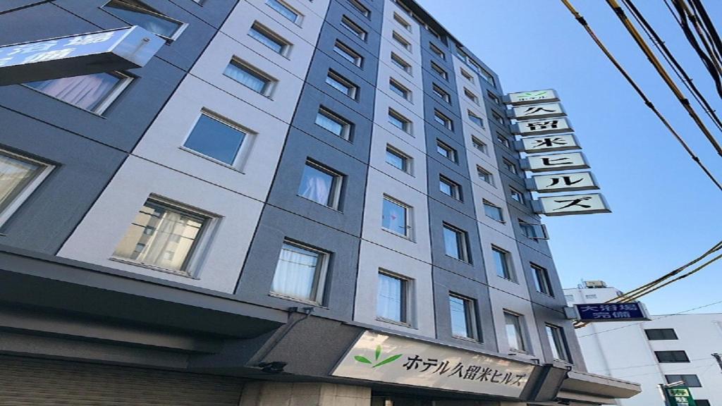a tall building with a sign in front of it at Hotel Kurume HIlls in Kurume