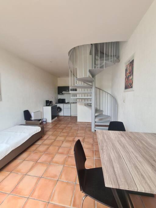 une chambre avec un lit, une table et un escalier dans l'établissement Maison dans le centre historique de tréguier, à Tréguier