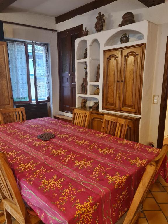 - une chambre avec un lit rouge et des placards en bois dans l'établissement Maison de village, à La Brigue