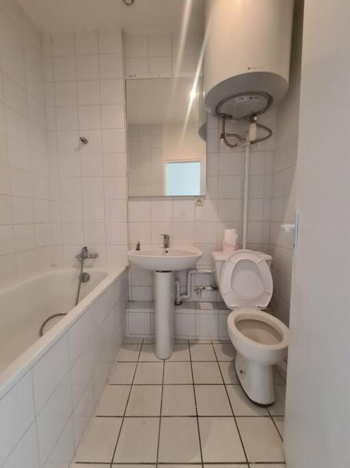 a white bathroom with a toilet and a sink at Maison dans le centre historique de tréguier in Tréguier