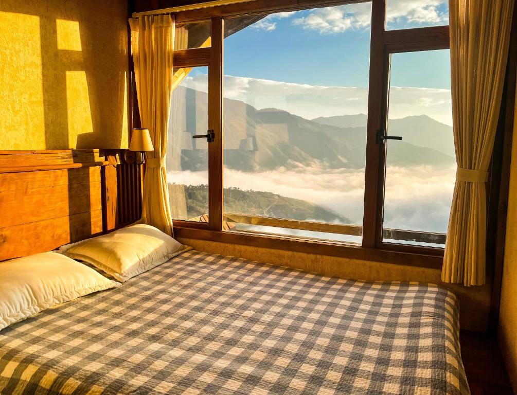1 dormitorio con 1 cama frente a una ventana en Cloud Forest Tà Xùa, en Bắc Yên