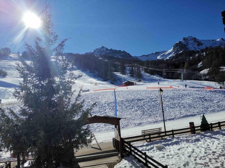 a snow covered ski slope with a snow covered ski lift at Studio front de neige - pieds des pistes in Enchastrayes