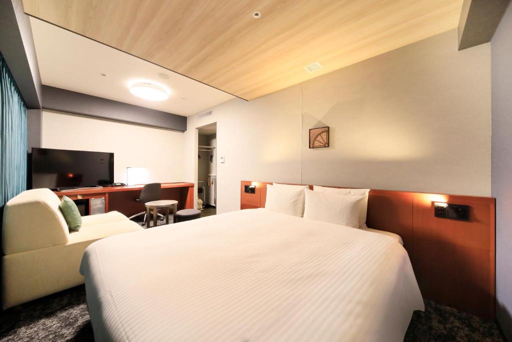 a hotel room with a large bed and a desk at Richmond Hotel Yokohama-Bashamichi in Yokohama