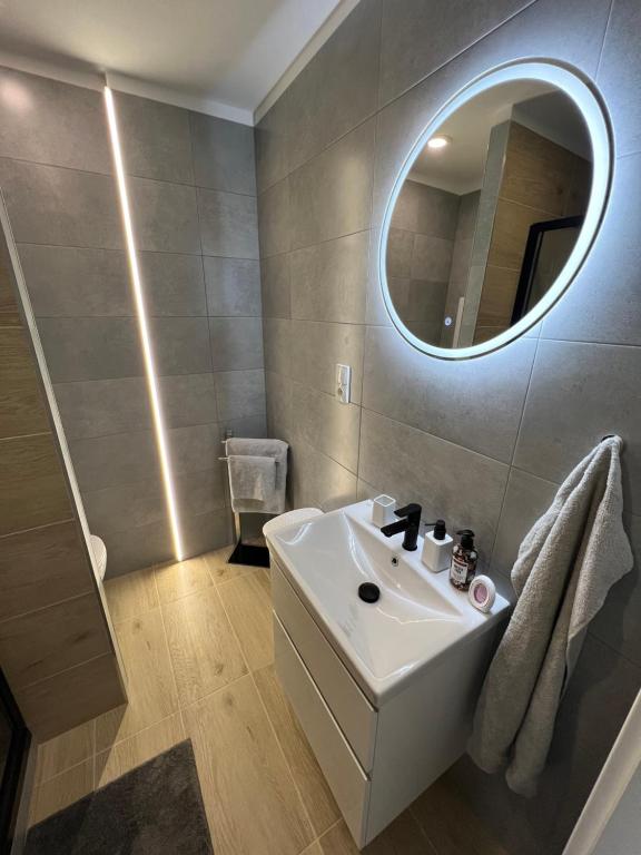 bagno con lavandino bianco e specchio di KOBRA Apartment a Moravská Ostrava