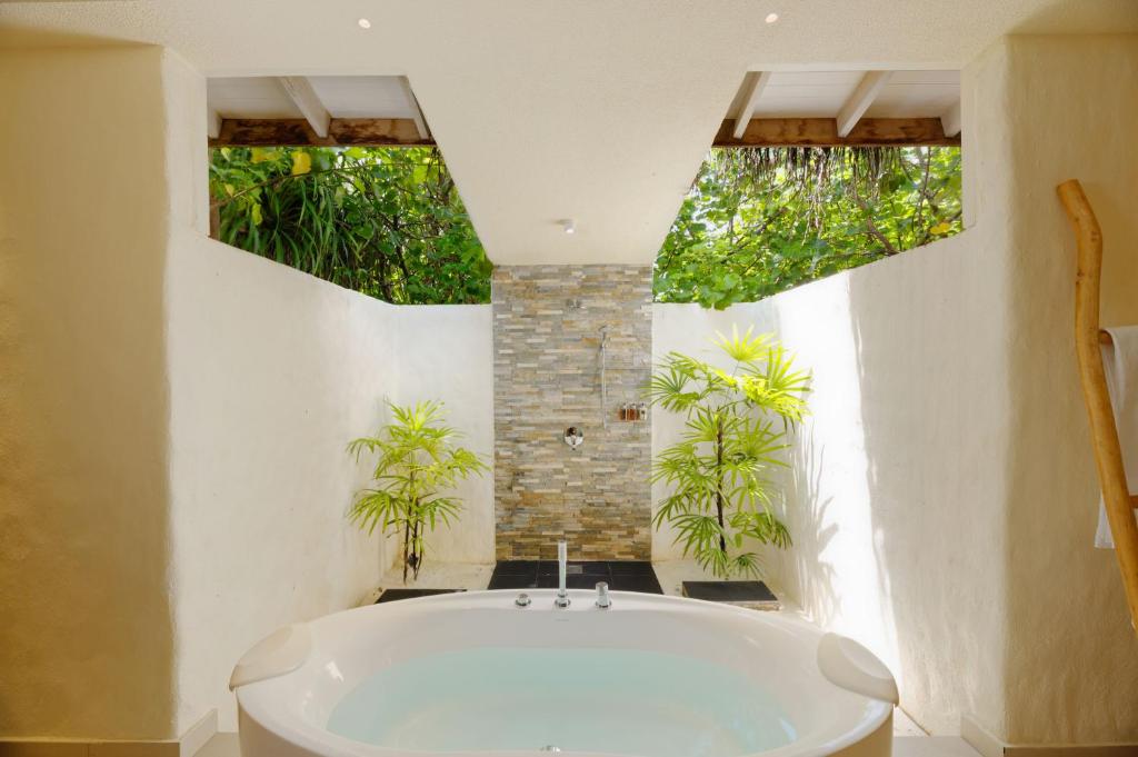 baño con bañera blanca y plantas en You & Me Maldives en Raa Atoll