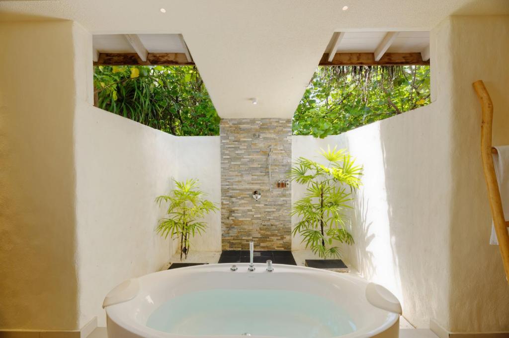 eine weiße Badewanne im Bad mit Pflanzen in der Unterkunft You & Me Maldives in Raa Atoll