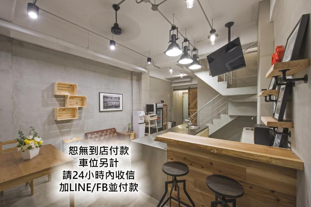 un ristorante con due sgabelli e un bancone in una stanza di OX Suites a Kaohsiung