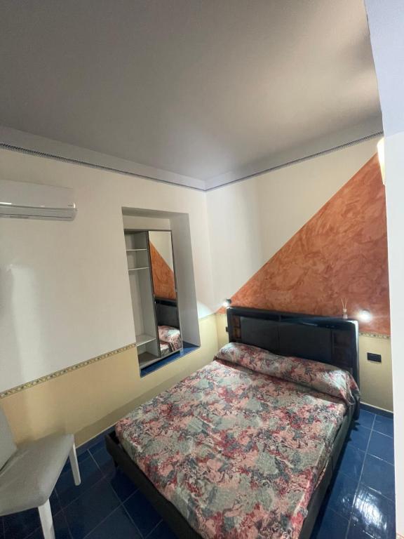 um pequeno quarto com uma cama e um espelho em Dal Torrese em Marina di Camerota