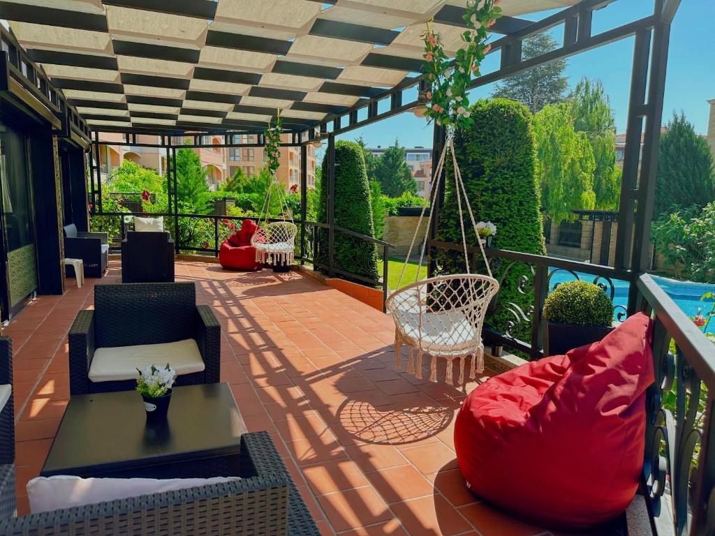 un patio con sedie e un cuscino rosso sul balcone. di Family Hotel Paradise a Sveti Konstantin i Elena