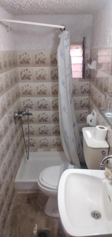 a bathroom with a toilet and a tub and a sink at Raymondos Apartments in Lassi