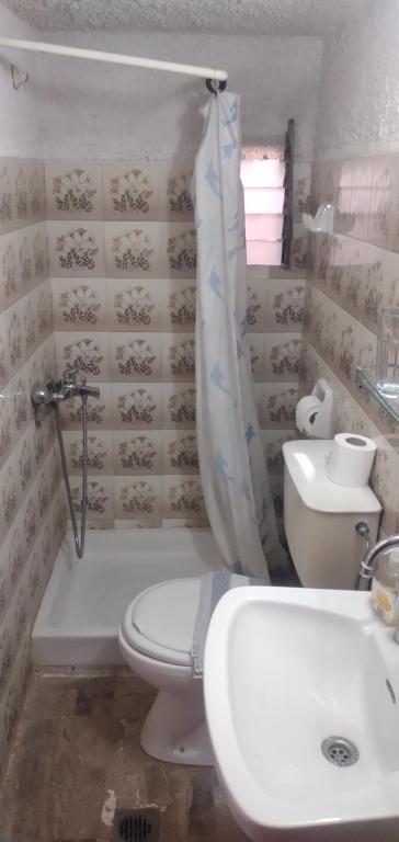 a bathroom with a toilet and a tub and a sink at Raymondos Apartments in Lassi