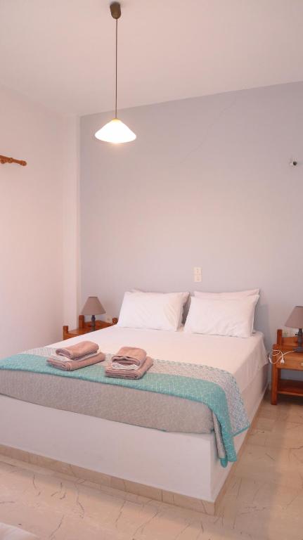 a bedroom with a white bed with towels on it at cosy apartment near the sea in Kókkinos Pírgos