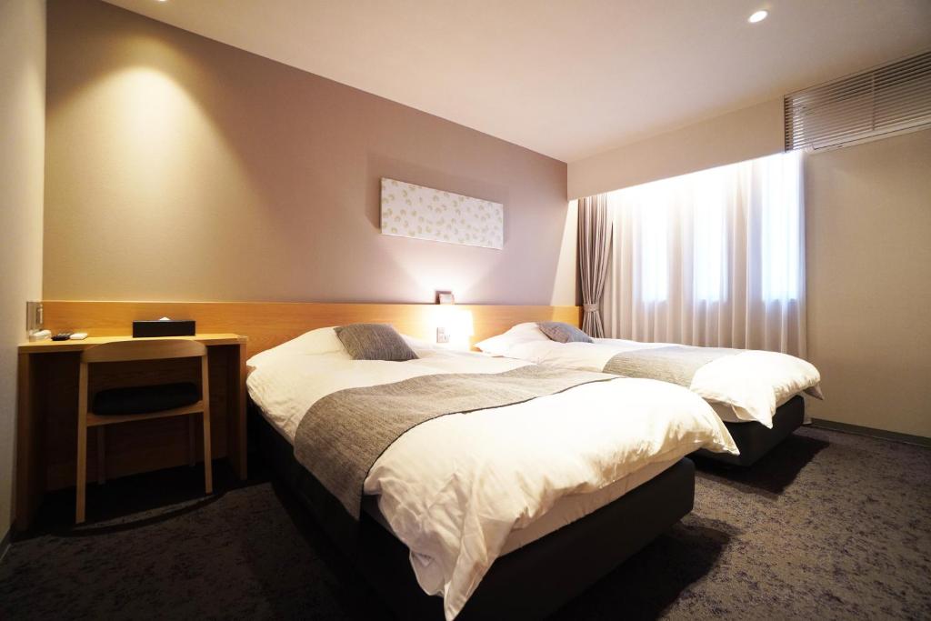 Nishinotōindōri的住宿－Avenir Hotel Kyoto，酒店客房设有两张床和窗户。