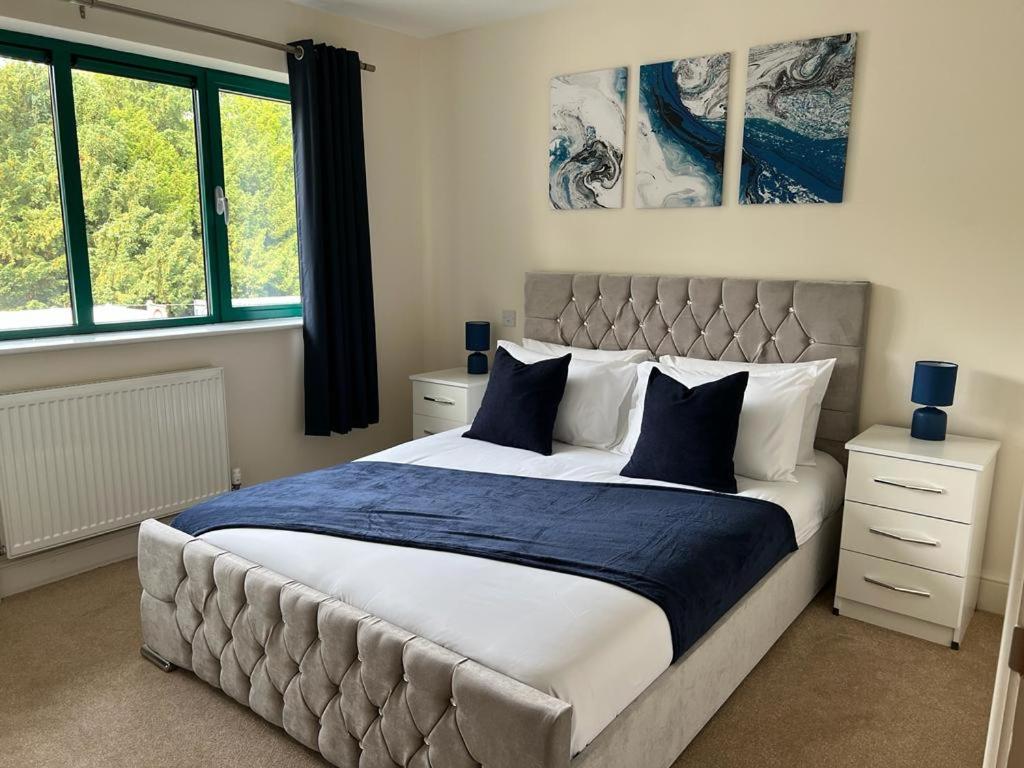 1 dormitorio con 1 cama grande con almohadas azules y blancas en Cambridge Apartment with free onsite parking en Cambridge