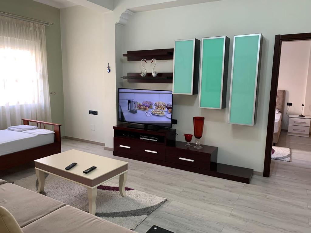 uma sala de estar com um sofá e uma televisão em Dadaj Apartments em Saranda