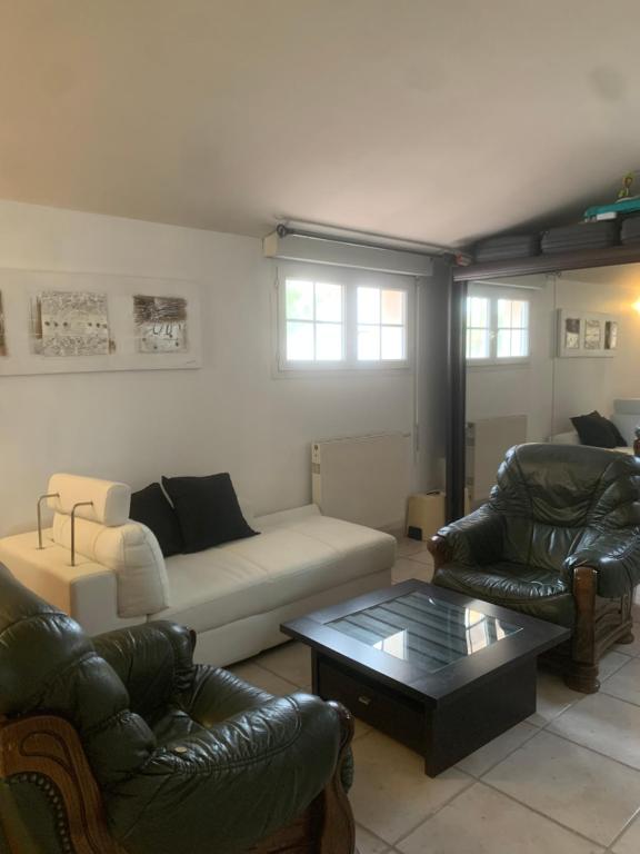 un salon avec un canapé et deux chaises dans l'établissement Appartement 4 personne à Rouffiac tolosan, à Rouffiac-Tolosan