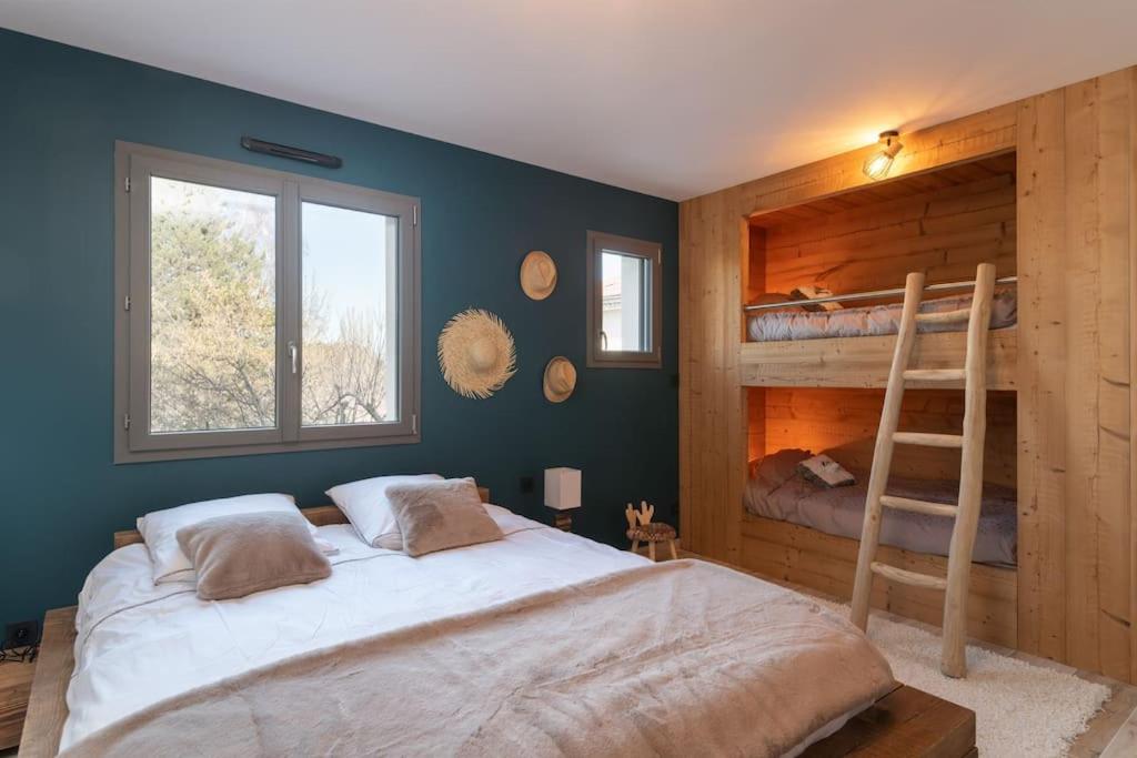 a bedroom with a bunk bed and a ladder at Le Clos du Chêne, maison avec sauna, spa et piscine in Hadol