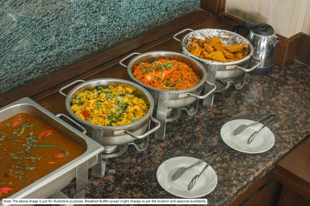 a group of three pots of food on a counter at Treebo Grand Vistara Airport Suites in Cochin