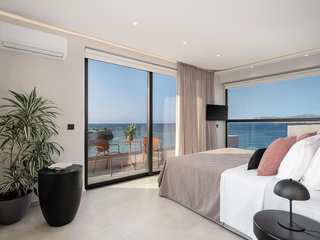 a bedroom with a bed and a view of the ocean at Theta Boutique Hotel in Chania Town