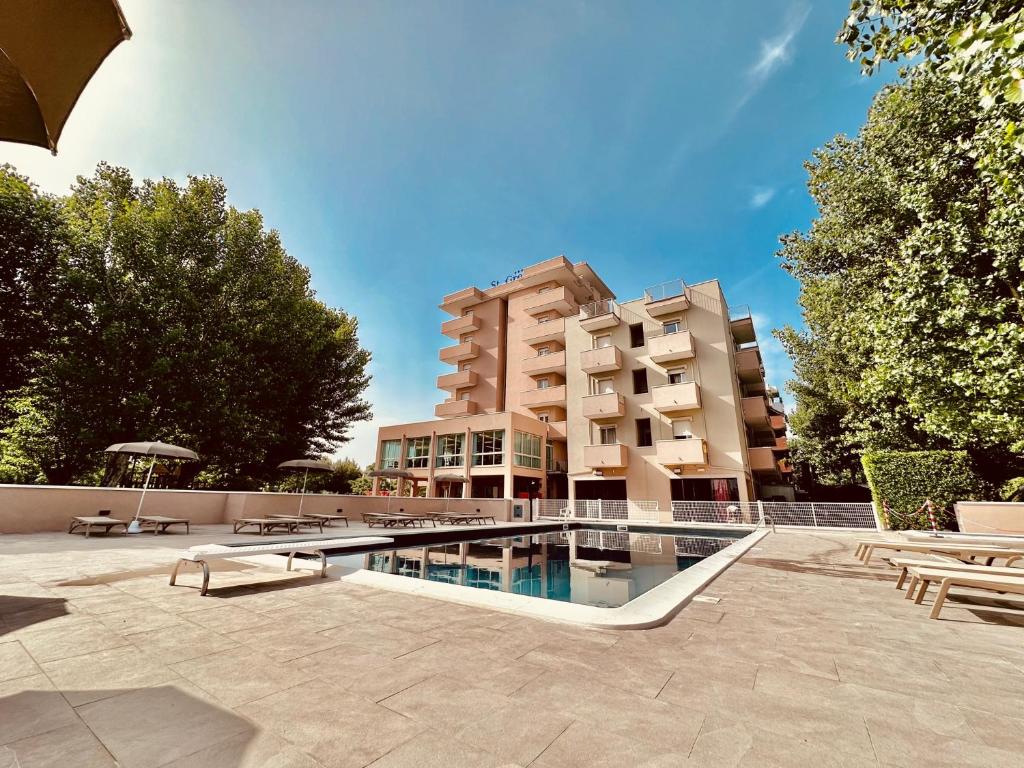 un hotel con piscina di fronte a un edificio di Hotel St Gregory Park a Rimini