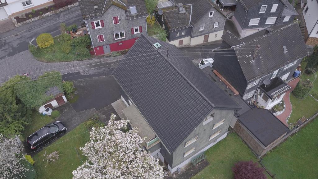 una vista aérea de una casa grande con coche en Gemütliche Wohnung im Herzen vom Dorf, en Mudersbach