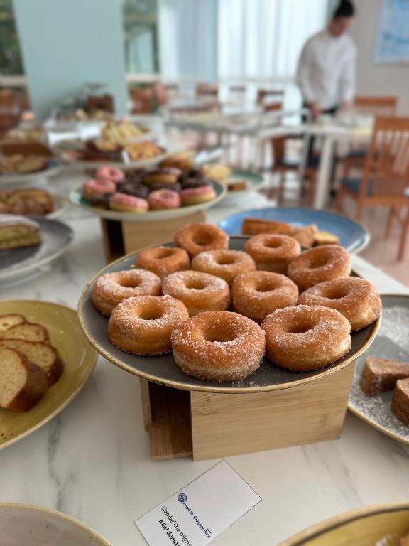 a table with plates of donuts on top at Hotel St Gregory Park in Rimini
