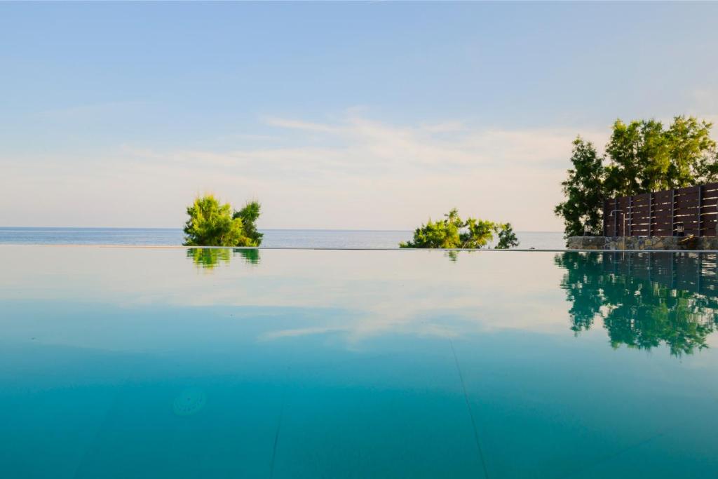 una piscina con el océano en el fondo en Villa Grand Blue, en Ierápetra