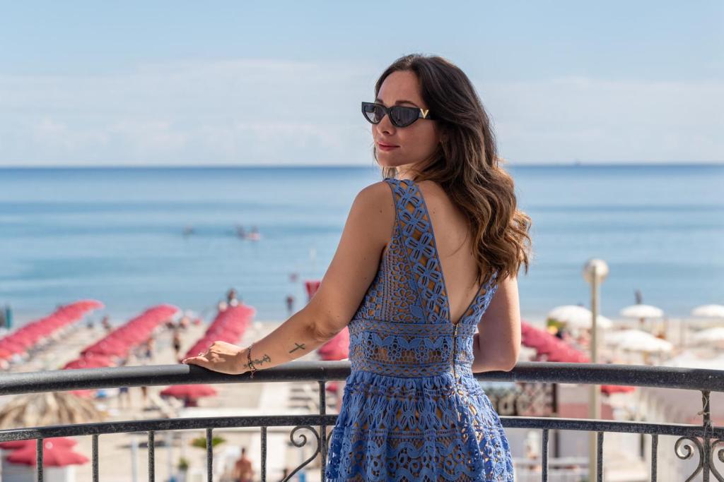 Eine Frau in einem blauen Kleid am Strand. in der Unterkunft Hotel Soraya - Spiaggia Sawasdee in Riccione