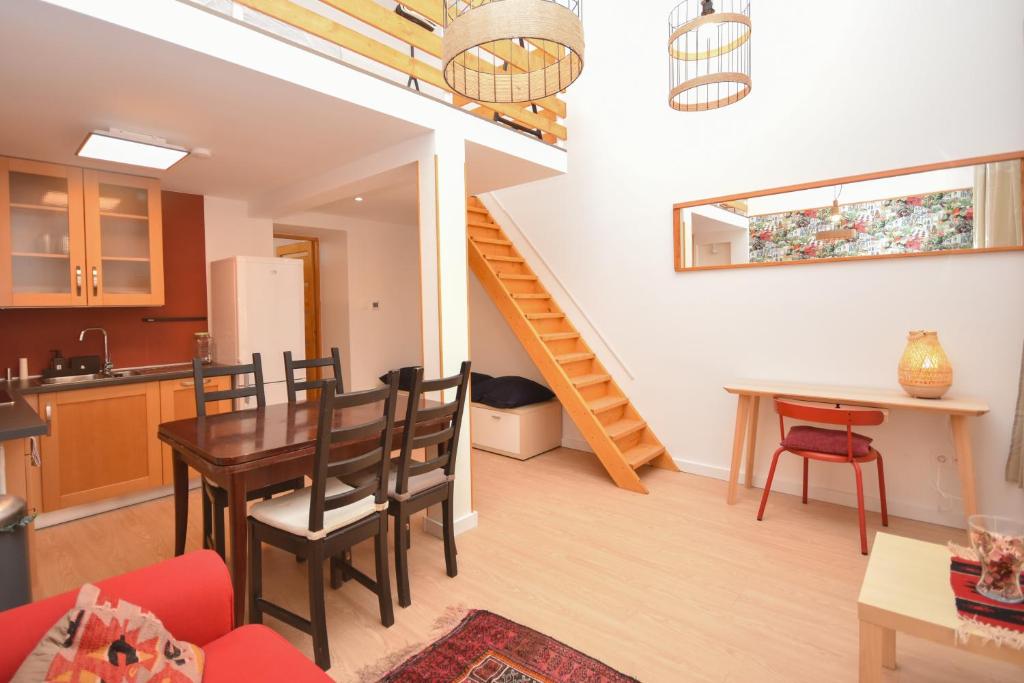 a kitchen and living room with a table and a staircase at Comfortable Apartament on the Boulevard for 4 people in Budapest