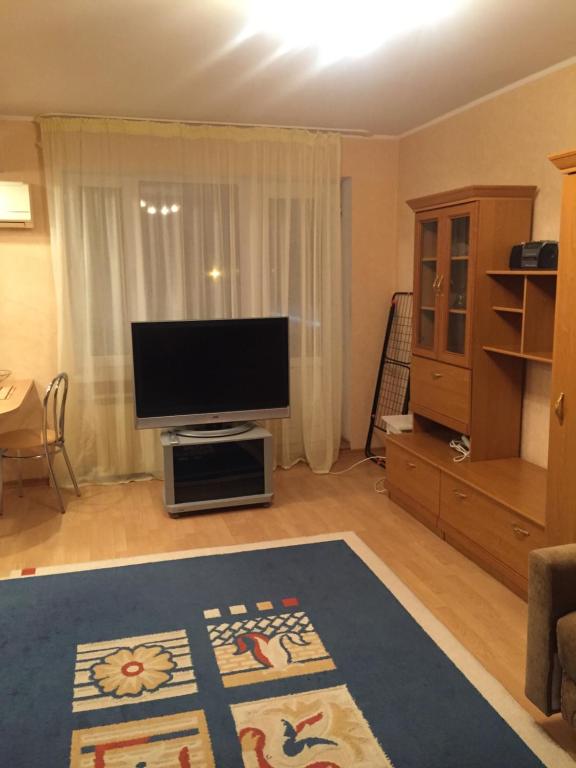 een woonkamer met een flatscreen-tv en een woonkamer bij Однокомнатная квартира посуточно in Balqash