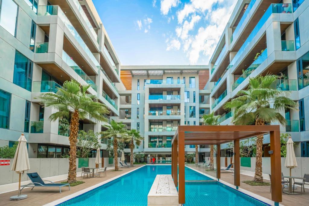 an image of a building with a swimming pool and palm trees at FAM Living City Walk - Opposite City Walk Mall - 2A in Dubai