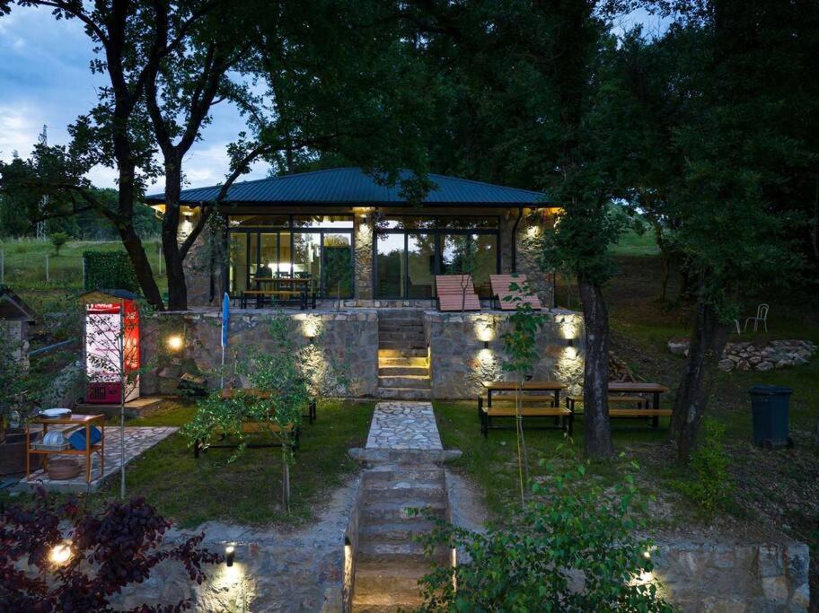 a backyard with a house with lights and a patio at Rijeka Zeta, Podgorica in Podgorica