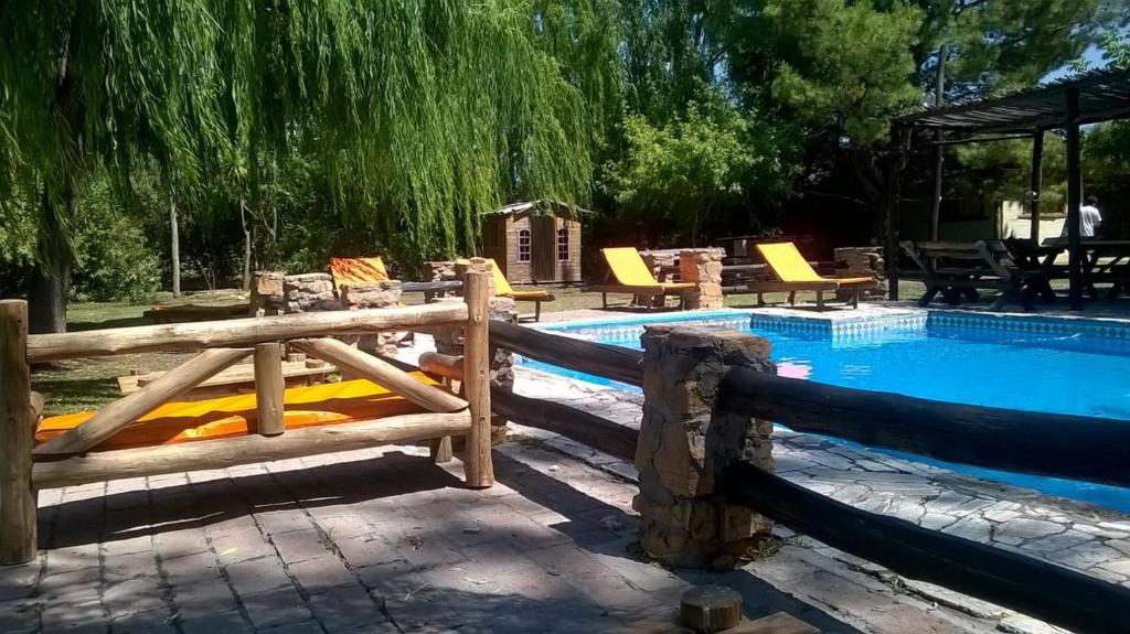 una piscina con una valla de madera al lado en Cabañas El Refugio del Atuel en San Rafael