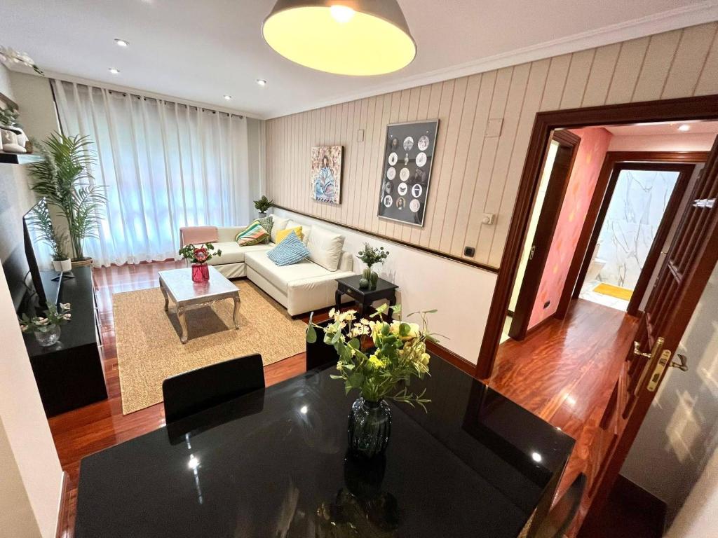 een woonkamer met een bank en een tafel bij Apartamento Olívico con Parking in Vigo