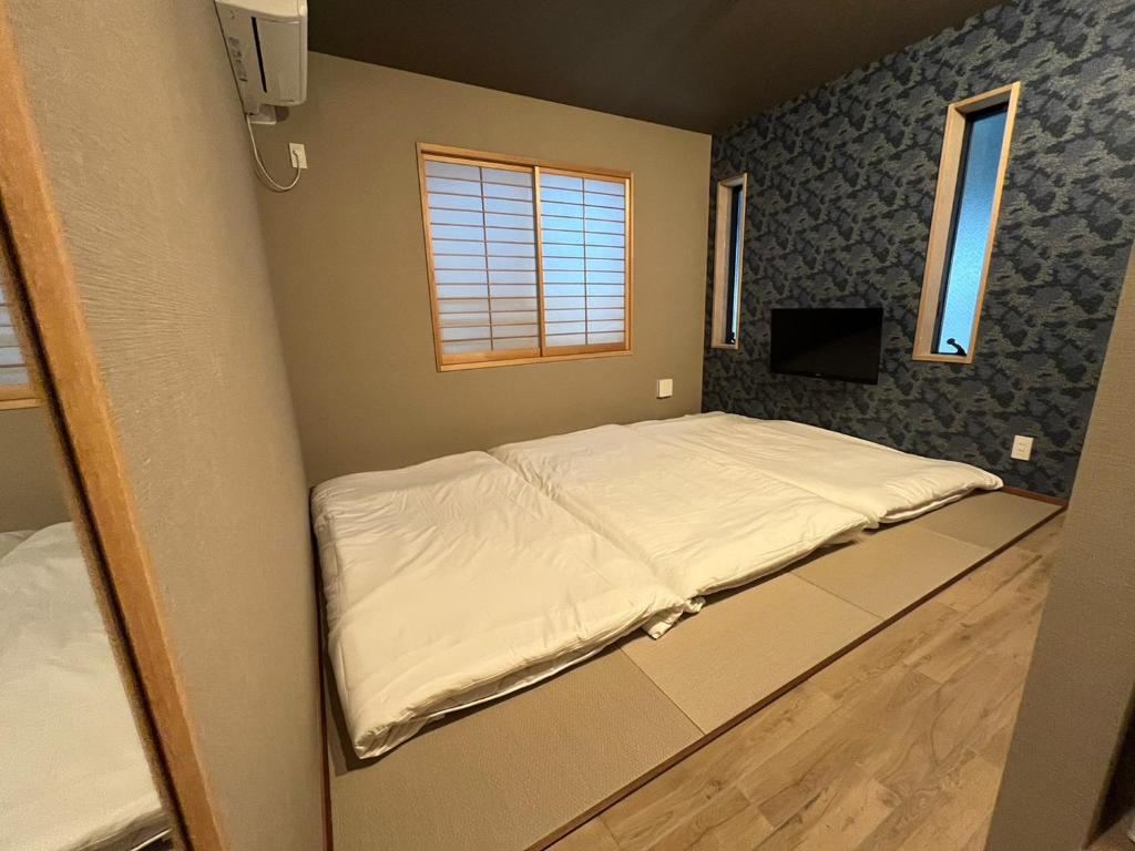 Un pequeño dormitorio con una cama en la esquina en Asagaya House, en Tokio