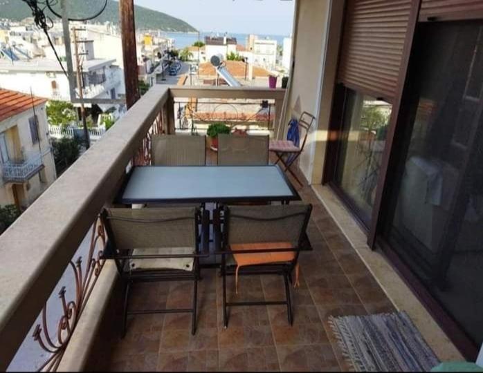 een patio met een tafel en stoelen op een balkon bij ANNASHOUSE in Néa Péramos