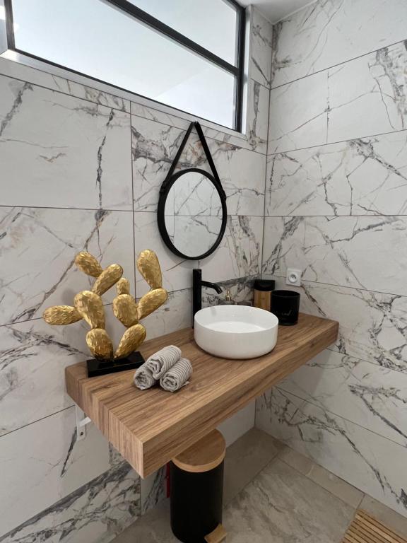 een badkamer met een wastafel en een spiegel op een aanrecht bij LE JEAN JAURÈS Arrivée Autonome in Vierzon