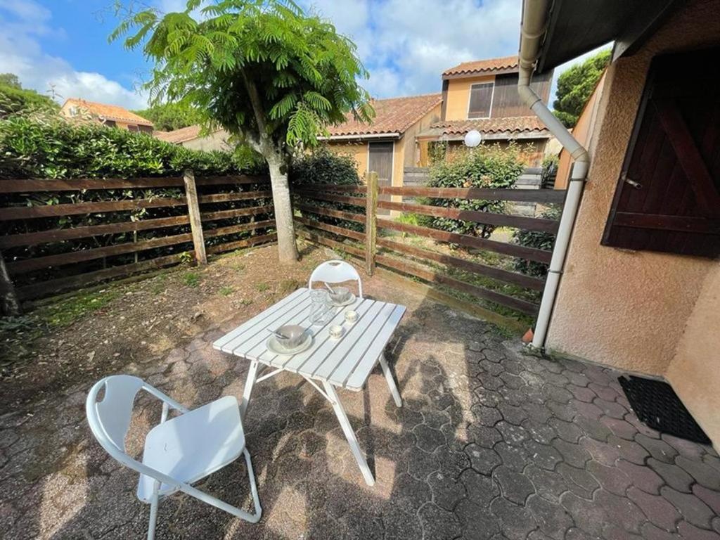 a white table and two chairs on a patio at Maison Capbreton, 2 pièces, 4 personnes - FR-1-413-100 in Capbreton