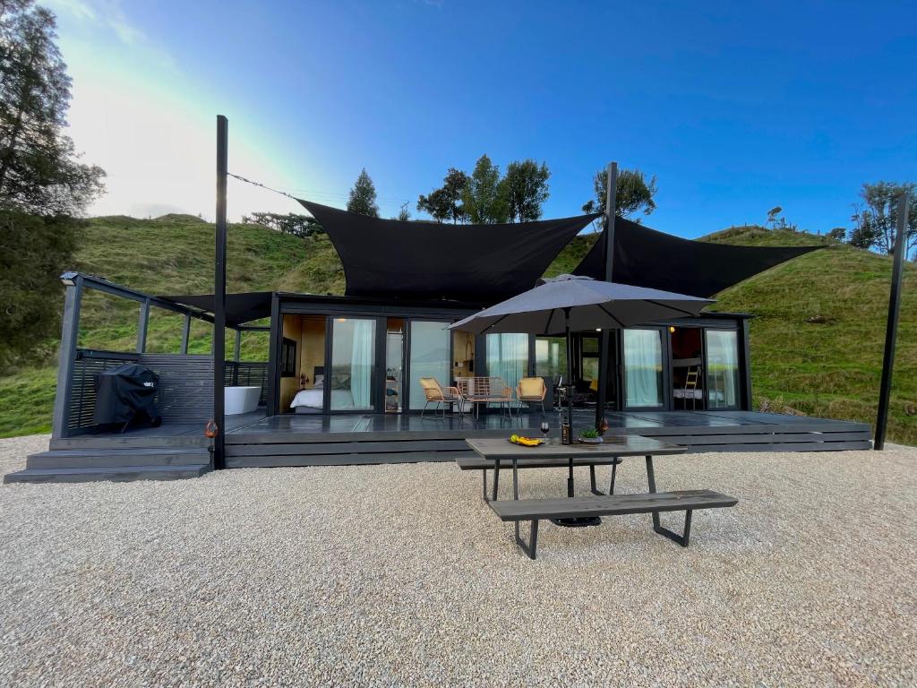 a house with a black roof and a table at Waitomo Retreat in Hangatiki
