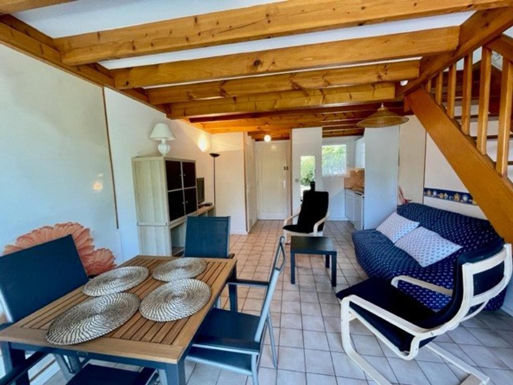 a living room with a wooden table and chairs at Maison proche plage avec jardinet, 3 pièces, 40m², parking privé, animaux acceptés - FR-1-478-131 in Saint-Pierre-Quiberon