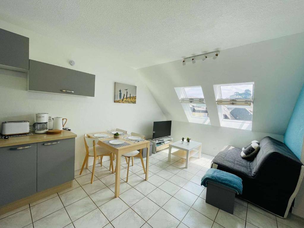 Cette chambre comprend une cuisine et une table avec table. dans l'établissement Appartement 3 étoiles à Perros-Guirec, plage de Trestraou, 2-4 pers, parking inclus, proche Thalasso - FR-1-542-44, à Perros-Guirec