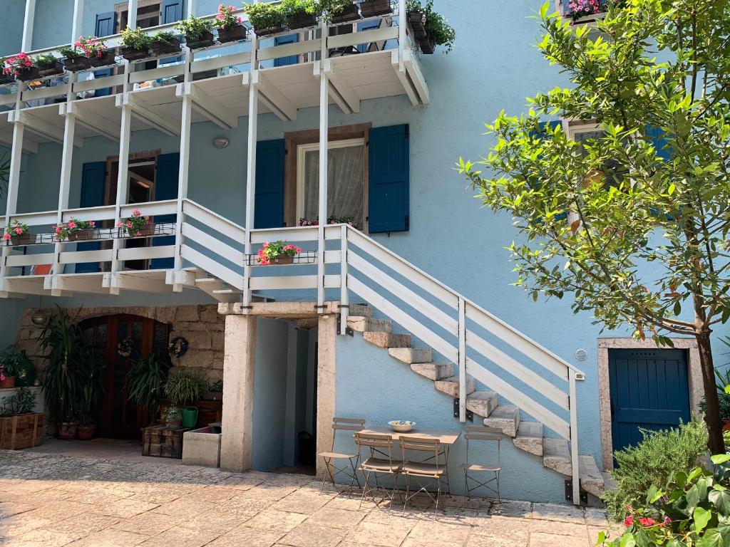 un edificio azul con escaleras y una mesa delante en MICASA ESTUCASA slow holiday, en Padergnone