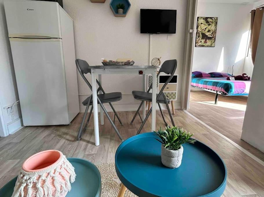 a living room with a table and a bed at BARCABEACH front de mer avec terrasse et parking in Le Barcarès